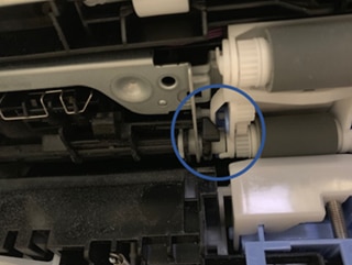 Image indicates an incorrect installation: White flag is binding  on the paper input unit
