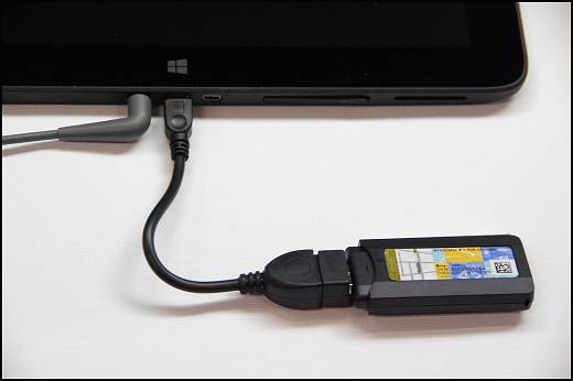  Foto que muestra un dispositivo de recuperación de HP conectado a la ranura microUSB de la tablet mediante un cable OTG.