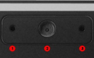 Vista en primer plano de la cámara web. El micrófono se encuentra del lado izquierdo del lente de la cámara, y el indicador LED sobre el lado derecho del lente de la cámara se ilumina para indicar que la cámara Web está encendida.