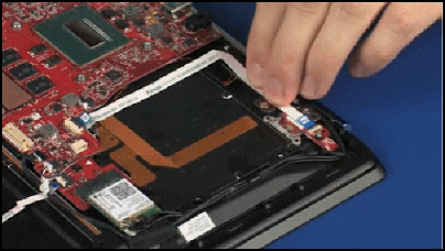 Applying pressure to the power button board ribbon cable to adhere it to the top cover