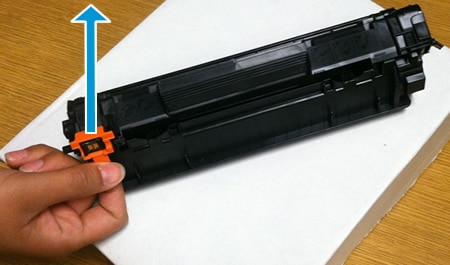Imagem: Remova a presilha laranja do cartucho de impressão.